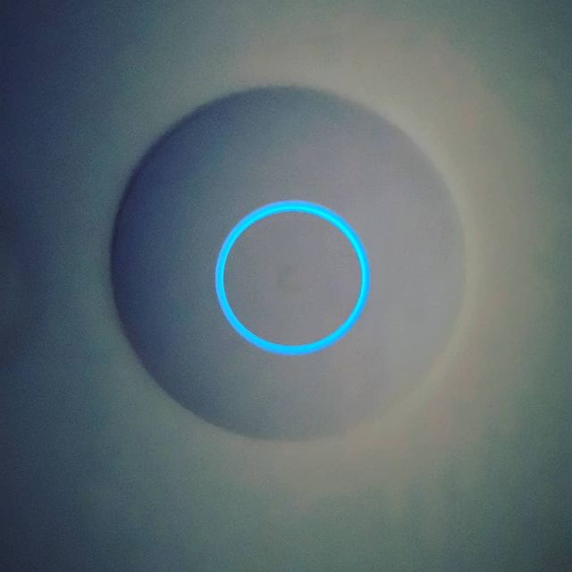 A ceiling mounted Access Point glowing